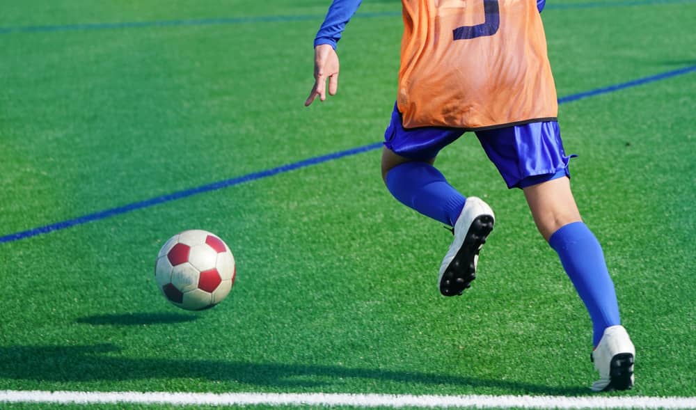 Niño jugando a fútbol con dolor de talón por Enfermedad de Sever